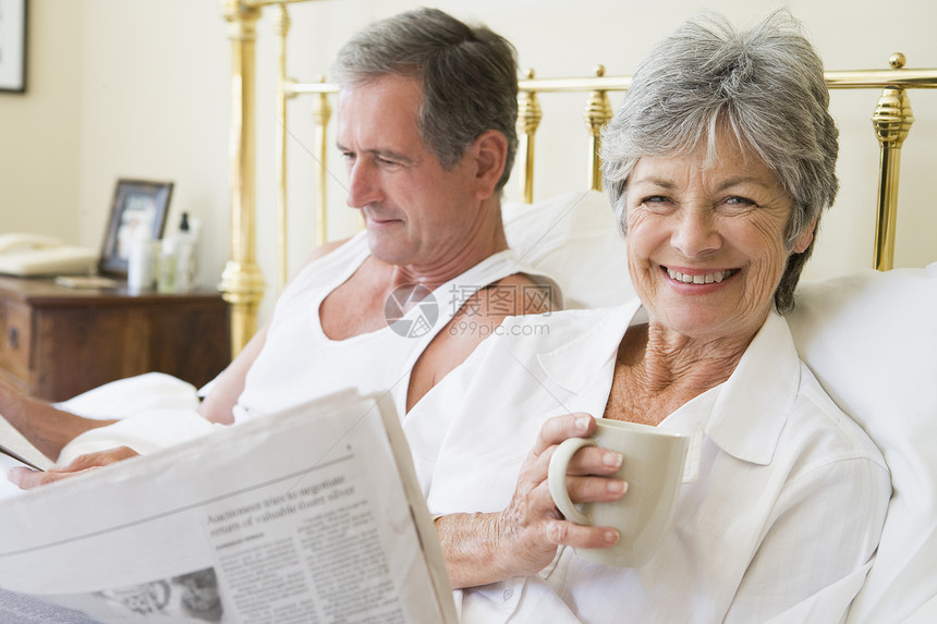在卧室的夫妇 咖啡和报纸笑着微笑丈夫退休两个人女性睡衣苏醒一杯茶阅读妻子夫妻图片