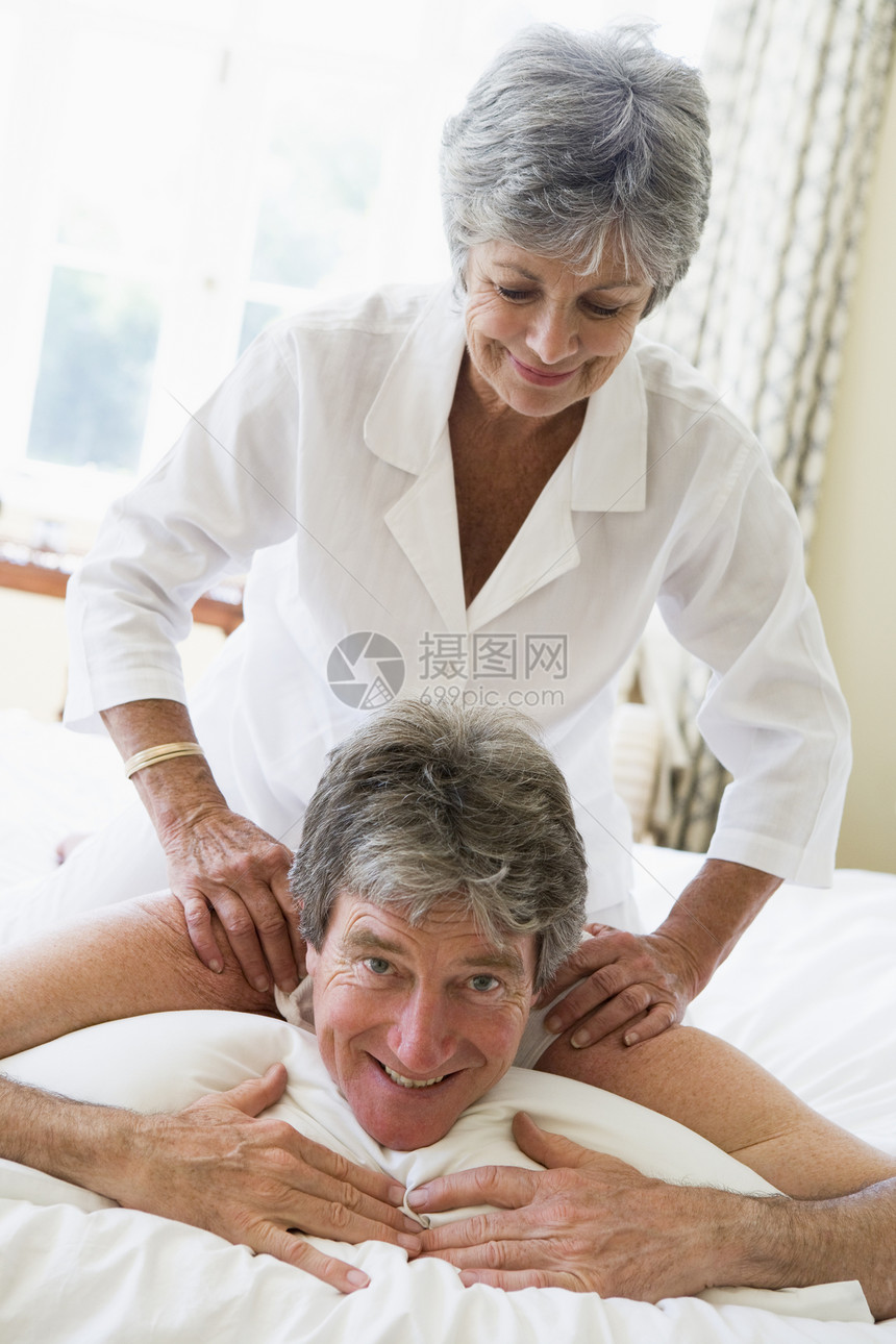 女人在卧室里微笑地给男人按摩男性苏醒女士水平夫妻退休女性两个人睡衣丈夫图片