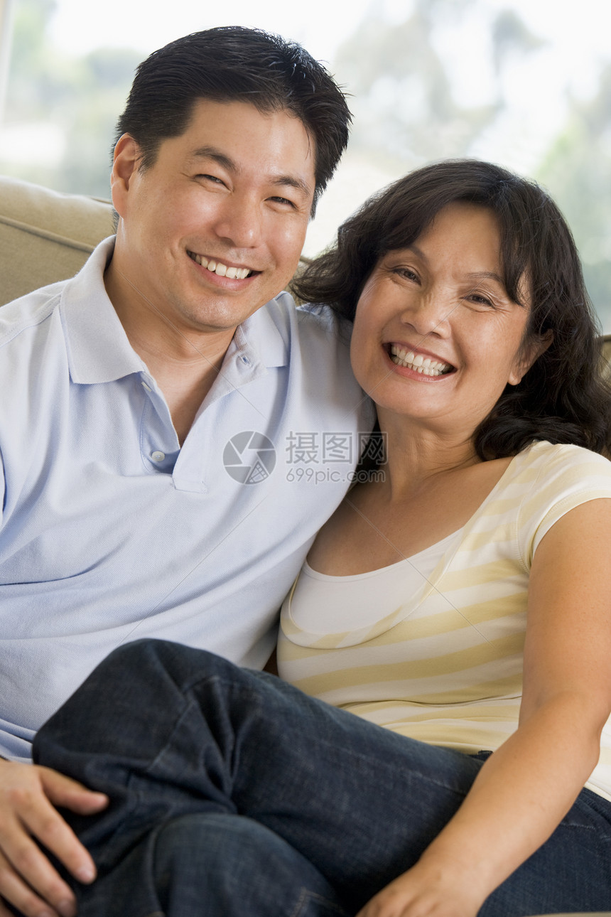 情侣在客厅放松 微笑长椅男性相机婴儿潮休息室女士妻子两个人家庭男人图片