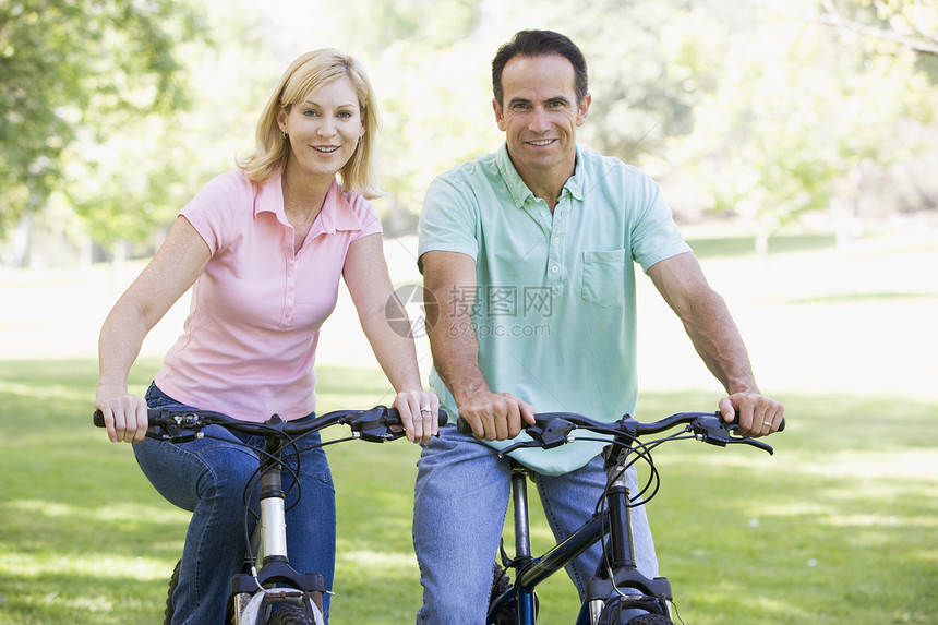 一对在户外骑自行车的夫妇微笑着男人女朋友妻子男朋友成人活动女士女性中年两个人图片