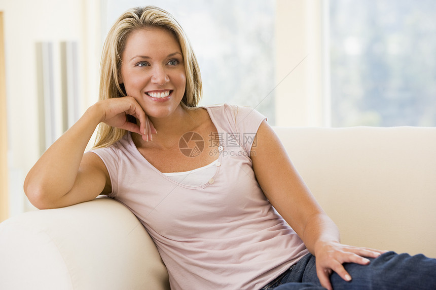 坐在起居室的妇女长椅成人休息室家庭世代客厅微笑沙发长度水平图片