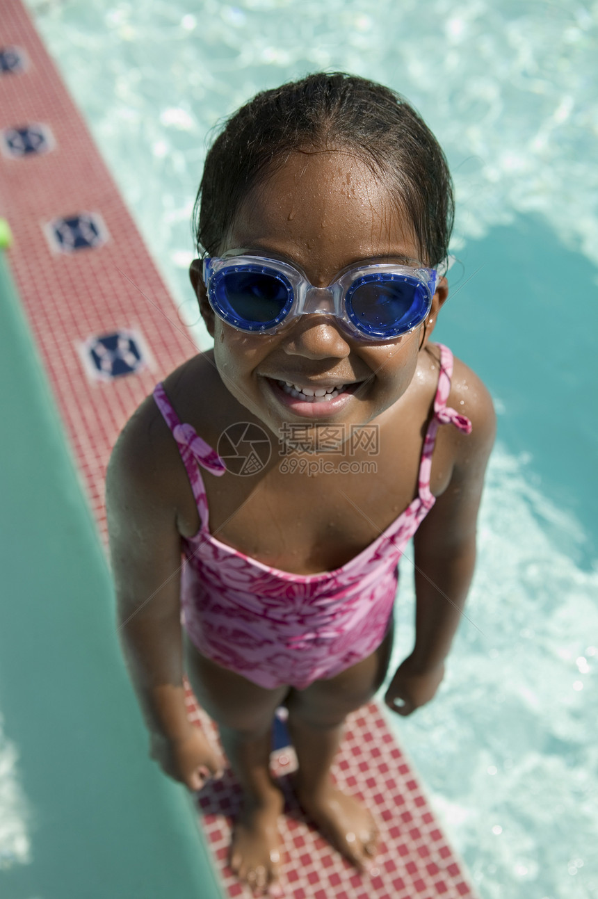 女孩在游泳池边缘戴护目镜图片