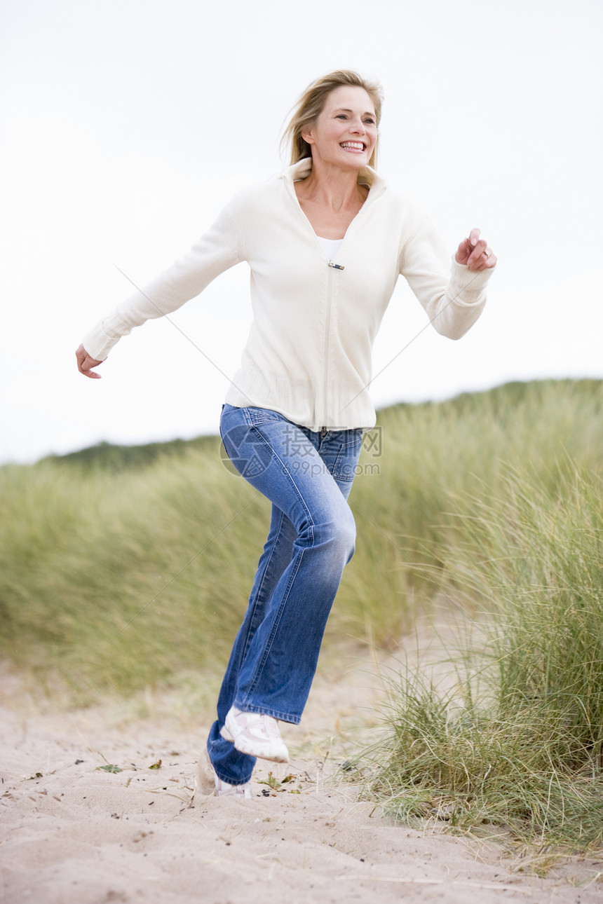 女人在海滩上欢笑沙丘偏移角低角度女性自由小路视角中年视图季节图片