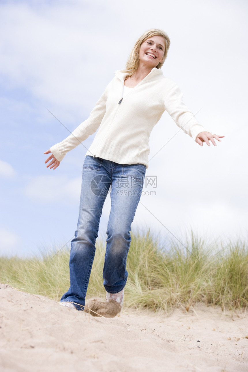 女人在海滩上微笑视角自由小路低角度视图途径季节偏移角踪迹沙丘图片