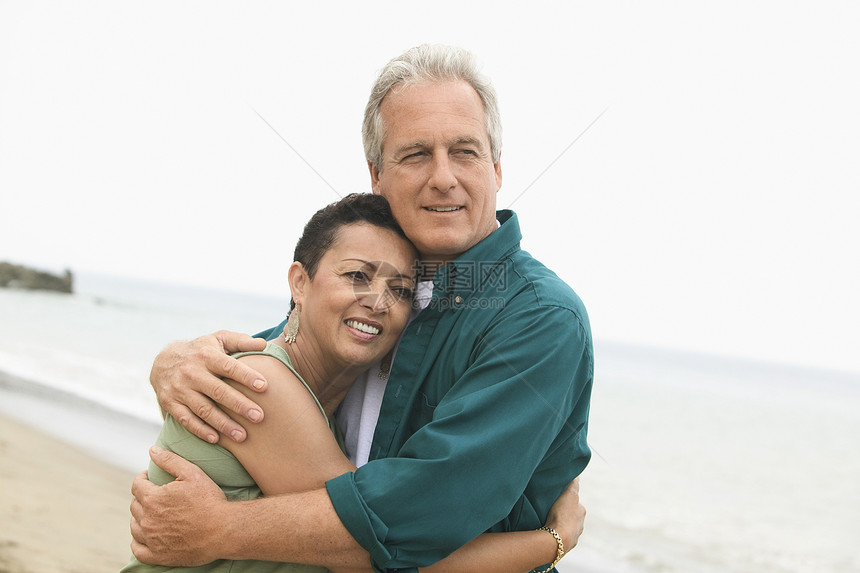 在海滩上拥抱情侣多样性女性时间活动伙计们种族空闲海岸成年人图片