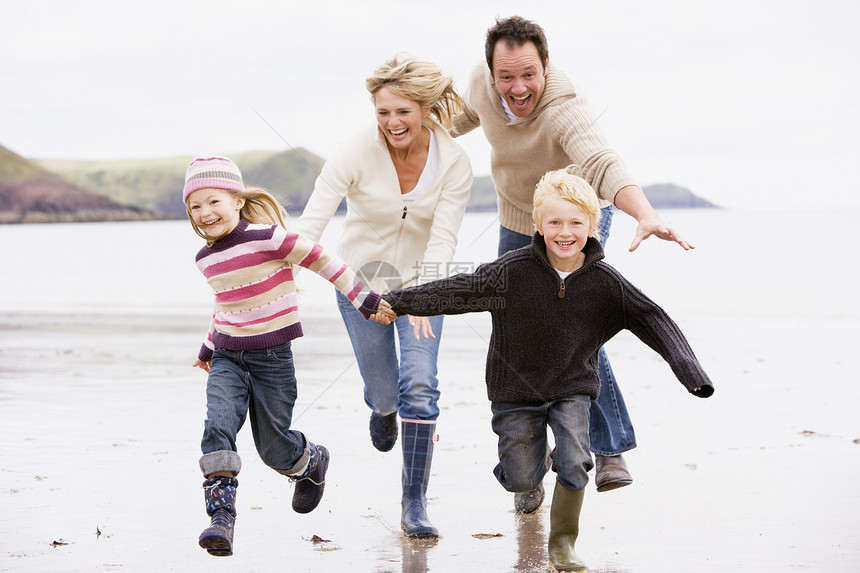 家人在沙滩上奔跑 手举手微笑图片