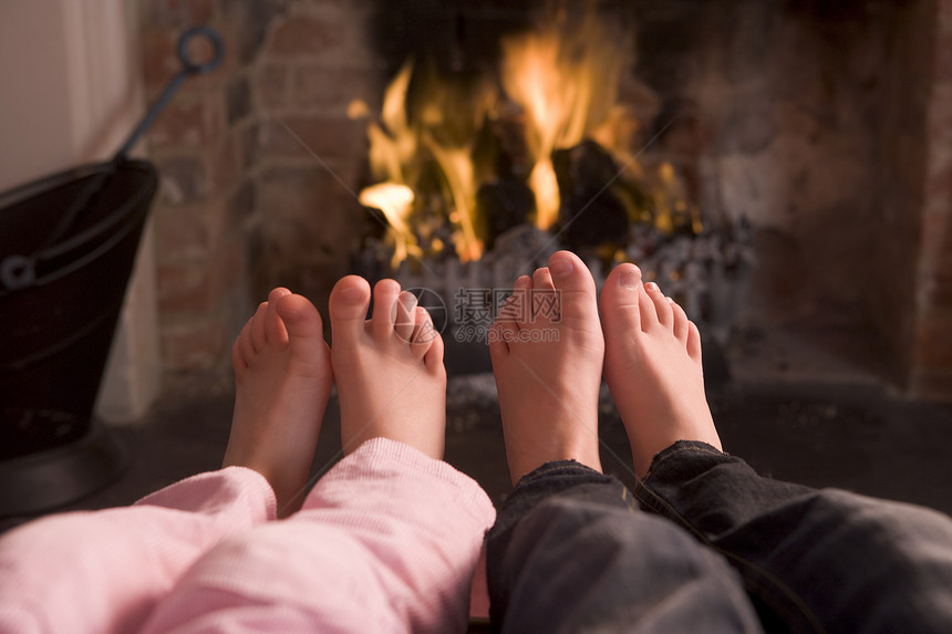 一对夫妇的脚在壁炉上升温两个人火焰小男孩男性男生兄弟姐妹女孩孩子季节脚趾图片