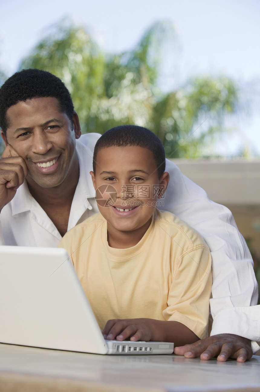 父亲和儿子使用笔记本电脑障碍爸爸网络成年人计算机男孩们技术硬件孩子们活动图片