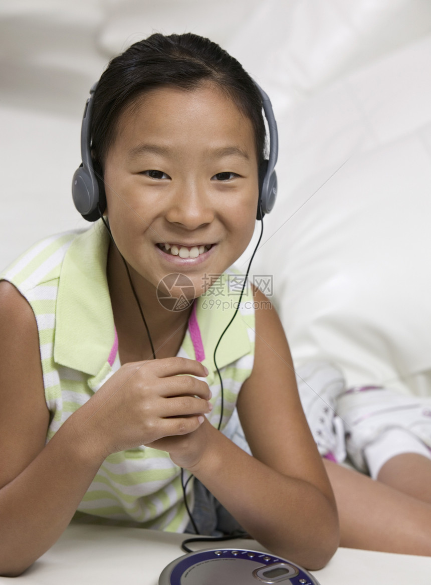 年轻女孩在耳语上听音乐图片
