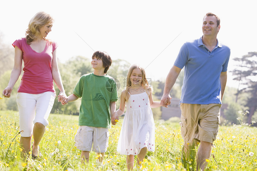 家庭在户外散步时笑着花朵的鲜花儿子中年妈妈微笑女性毛茛男性农村场地享受图片
