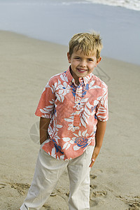 海滩上的男孩娱乐服装休闲海岸衣服服饰眼神孩子衬衫摄影背景图片