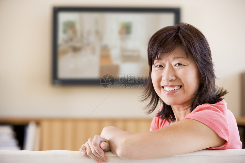 妇女笑着看电视沙发成人相机女性客厅屏幕电视中年女士婴儿图片