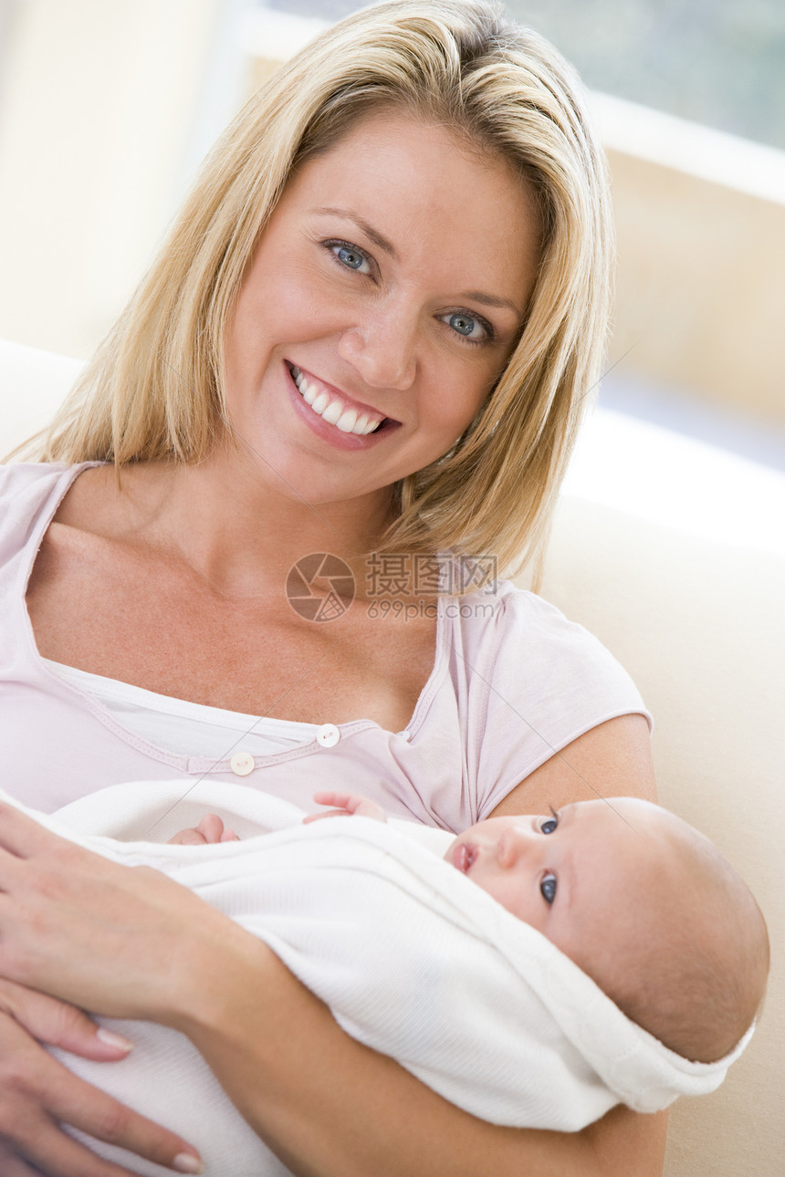 母亲在起居室 婴儿微笑妈妈客厅两个人拥抱沙发女儿家长女士新生孩子图片