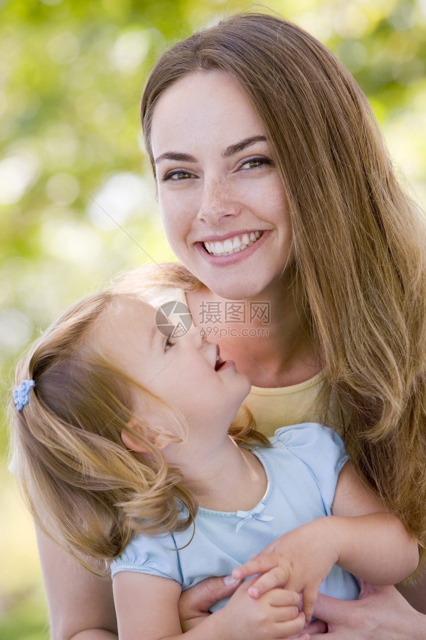 母亲抱着女儿在户外微笑两个人女士妈妈亲热拉丁公园家长女性拥抱感情图片