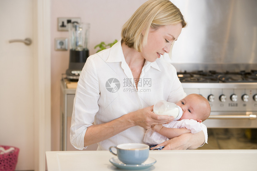 在厨房用咖啡给婴儿喂奶图片