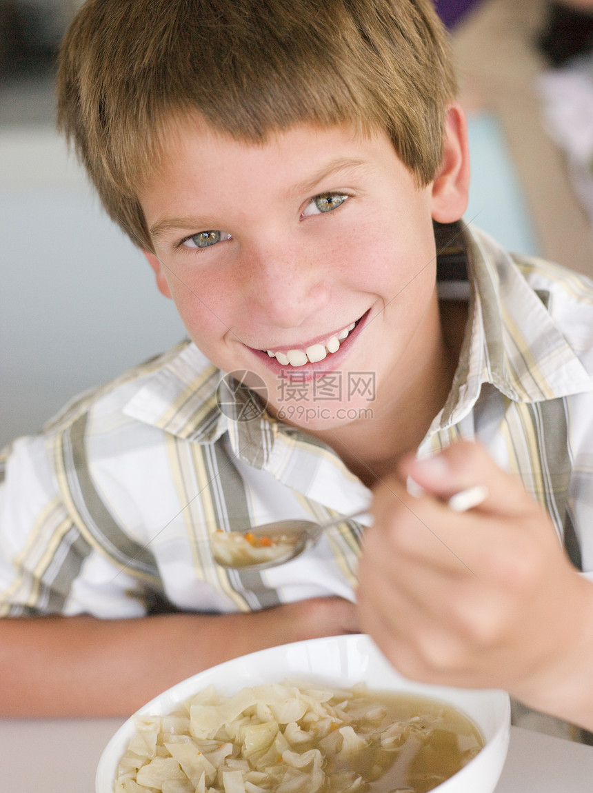 在厨房的男孩 喝着汤 笑着微笑图片