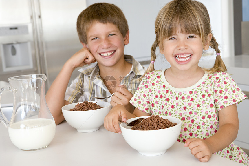 两个儿童在厨房里 笑着吃麦片图片