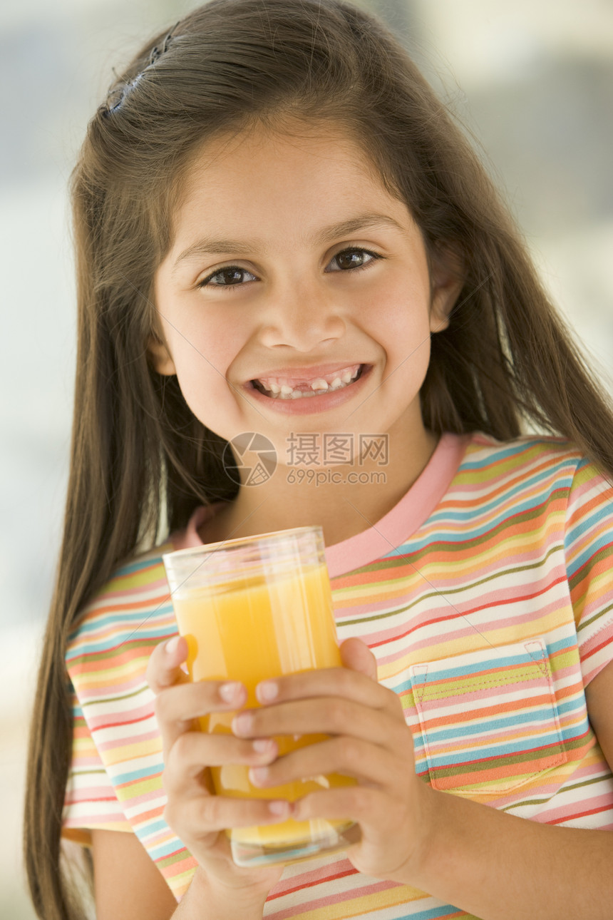 室内年轻女孩在喝橙汁时微笑儿童一个女孩拉丁牙裔果汁孩子们混血儿食品孩子食物图片