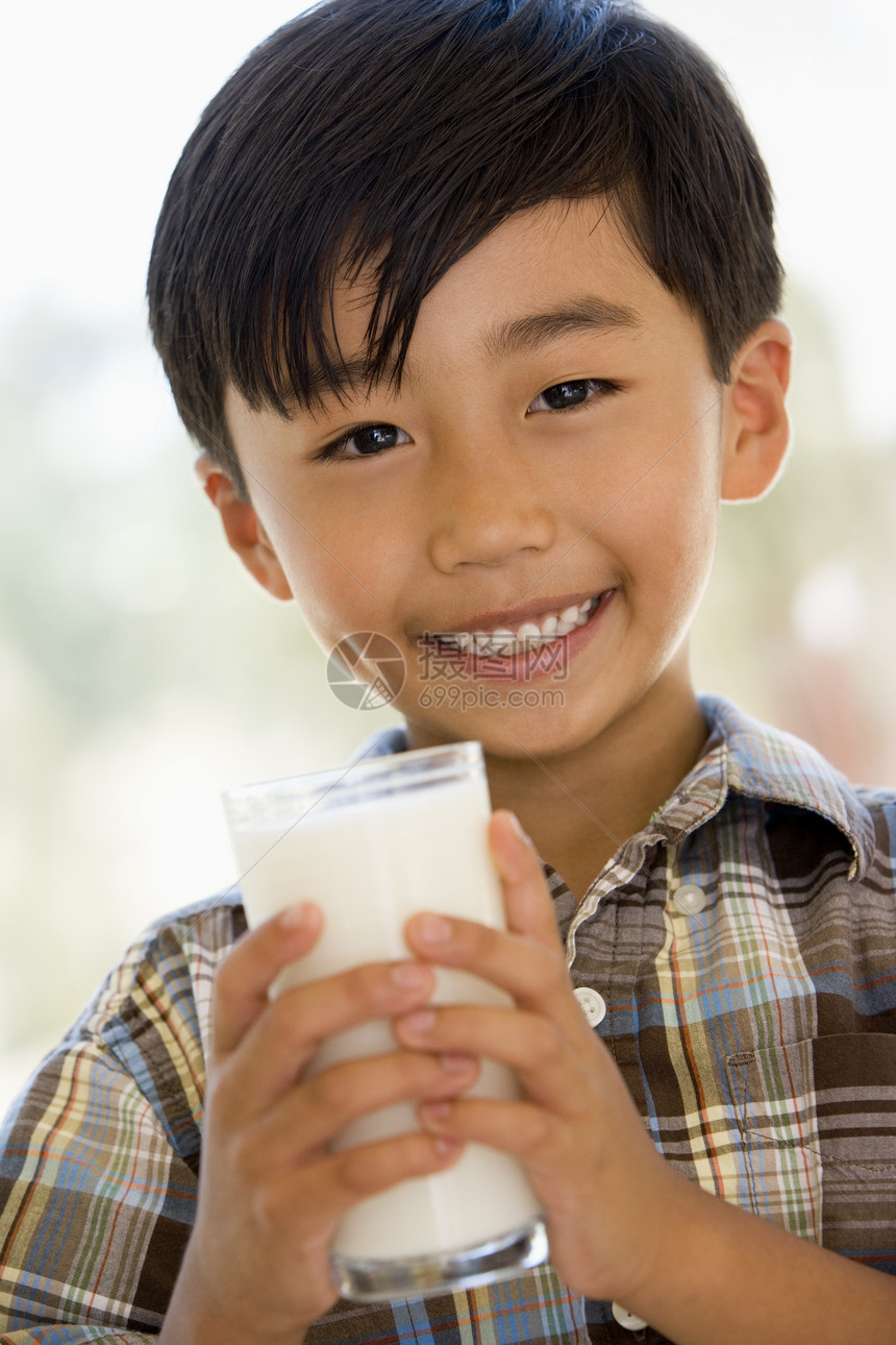 在室内喝着微笑的牛奶的年轻男孩奶制品食品小男孩玻璃食物孩子们儿童孩子一个男孩图片