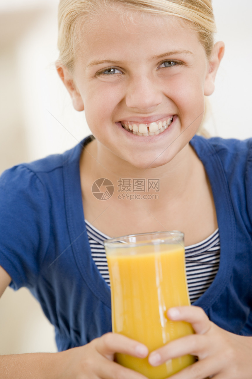 室内年轻女孩在喝橙汁时微笑儿童食物孩子们食品一个女孩享受孩子果汁图片