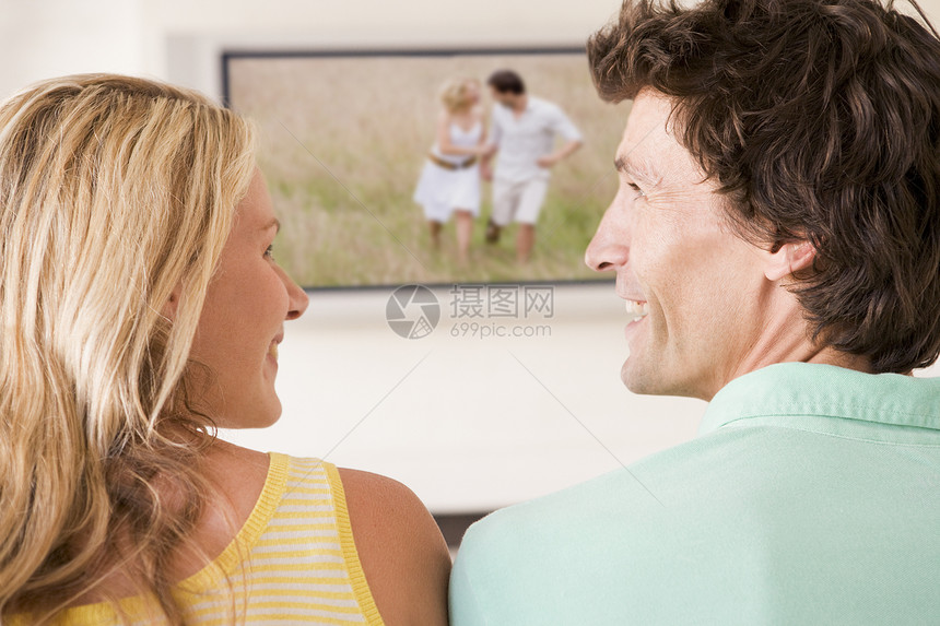 在客厅的一对夫妇 看着电视笑着遥控世代纯平男性两个人丈夫家庭屏幕平面女性图片