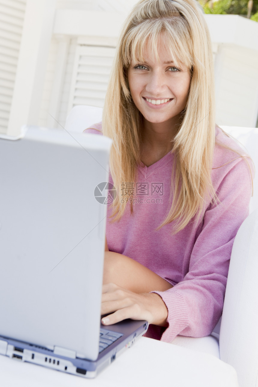 使用笔记本电脑微笑的院子上的妇女女子台椅技术互联网后院上网家具露台图片