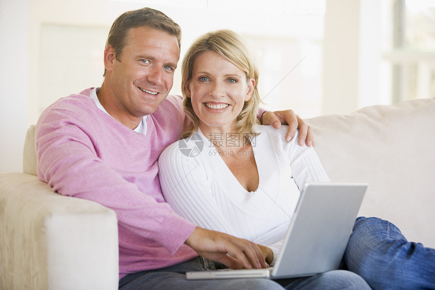 使用笔记本电脑和微笑在客厅的一对夫妇家庭休息室上网技术女士世代女性互联网男性沙发图片