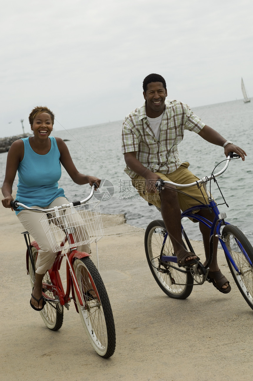 海滩上有双自行车的一对夫妇空闲时间享受女性娱乐成年人能力海岸活动种族图片