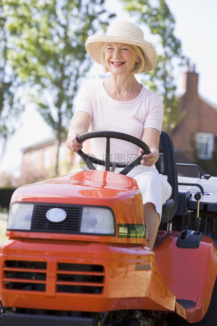 女性户外驾驶草坪手的女士微笑草地退休花园割草机园艺后院图片