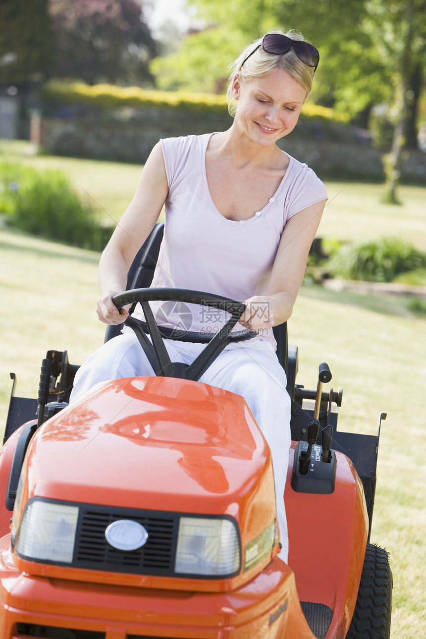 女性户外驾驶草坪手的女士微笑园丁园艺女子花园草地后院割草机成人图片