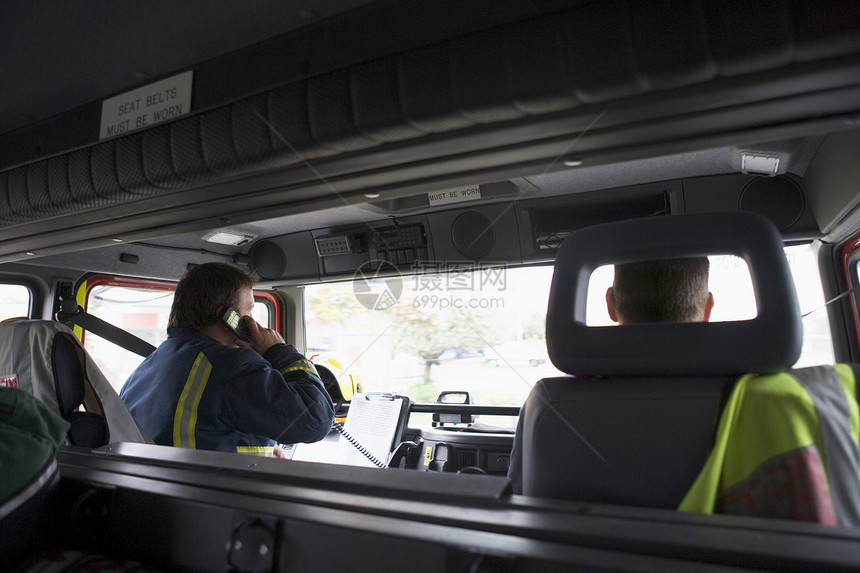 消防员在前往紧急现场的路上中年人男人英雄情况司机服务两个人水平运输电话图片