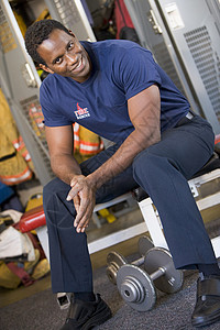 在消防站更衣室对消防员的肖像男人制服中年消防消防服微笑权重消防队员英雄好榜样背景图片