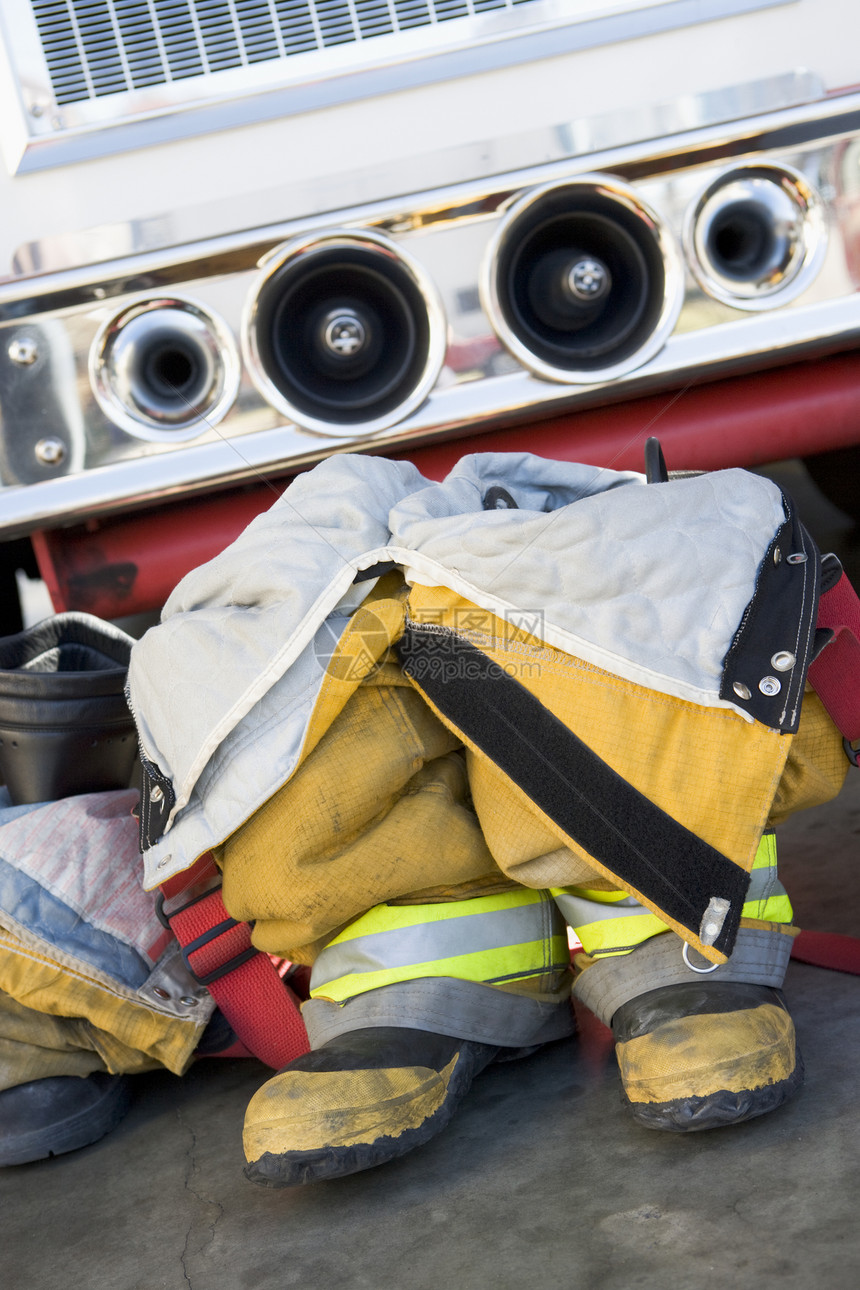 空空消防员的靴子和制服 在消防车旁边裤子吊带裤职业安全消防服情况消防服务车辆消防队员图片