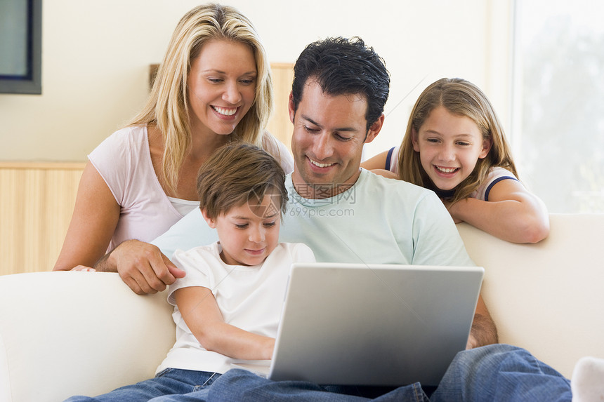 家庭在起居室 膝上型电脑微笑互联网女士孩子笔记本妈妈女子男人女孩们父亲爸爸图片