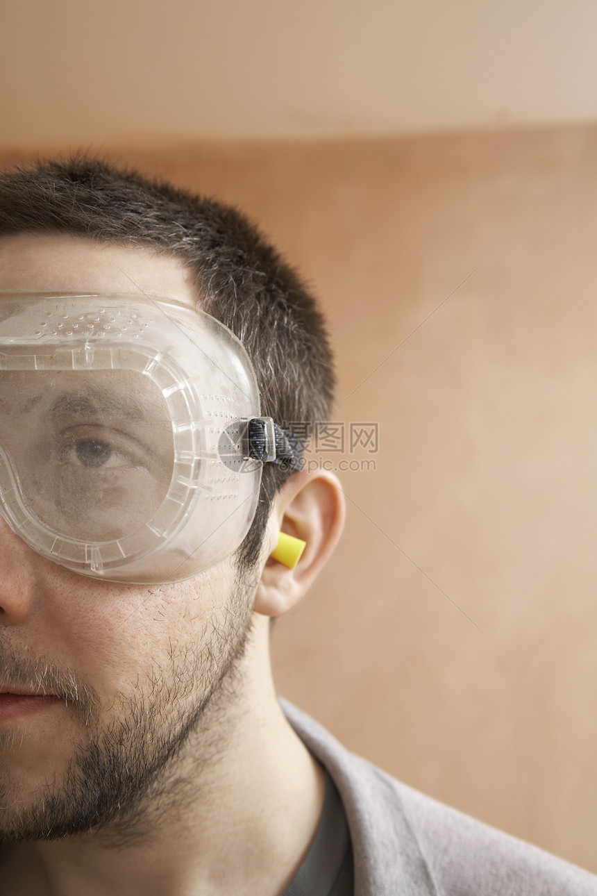 戴防护眼镜和耳塞的男子图片