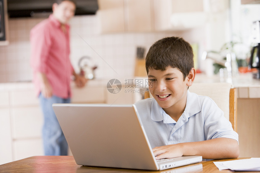 厨房里的小男孩 带着笔记本电脑和文件与男人微笑图片