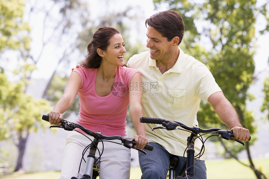 一对在户外骑自行车的夫妇微笑着女性踪迹丈夫妻子山地公园拉丁男性骑术农村图片