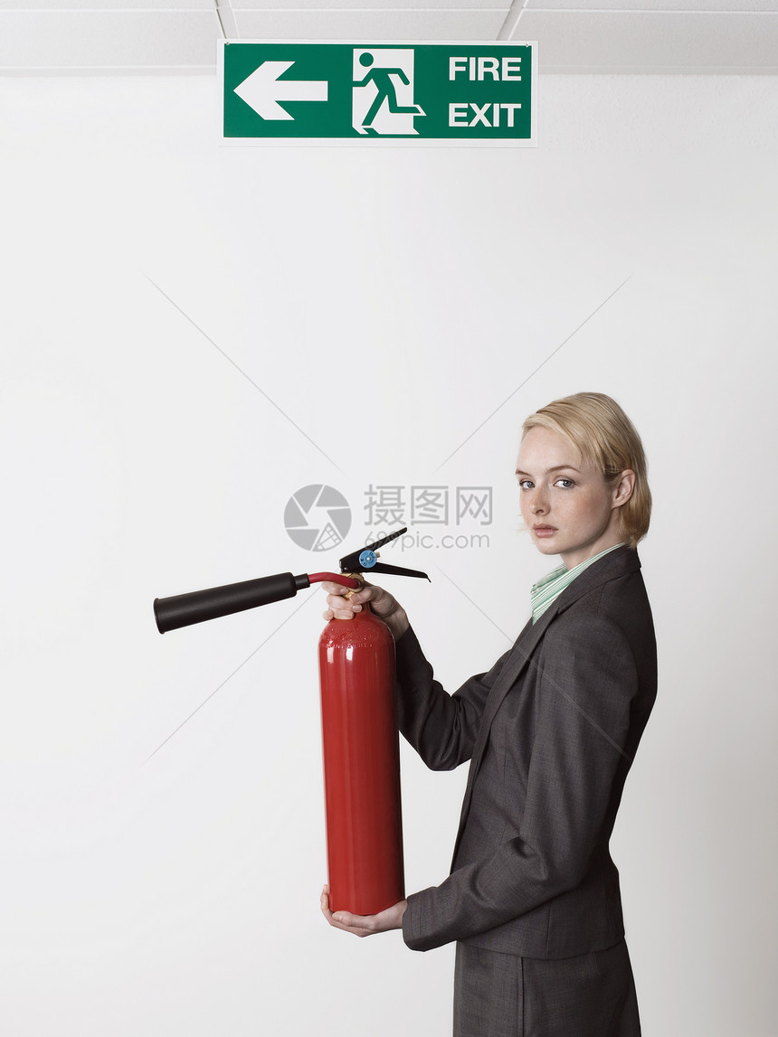 持有退出标志下除火灭火的女商务人士图片
