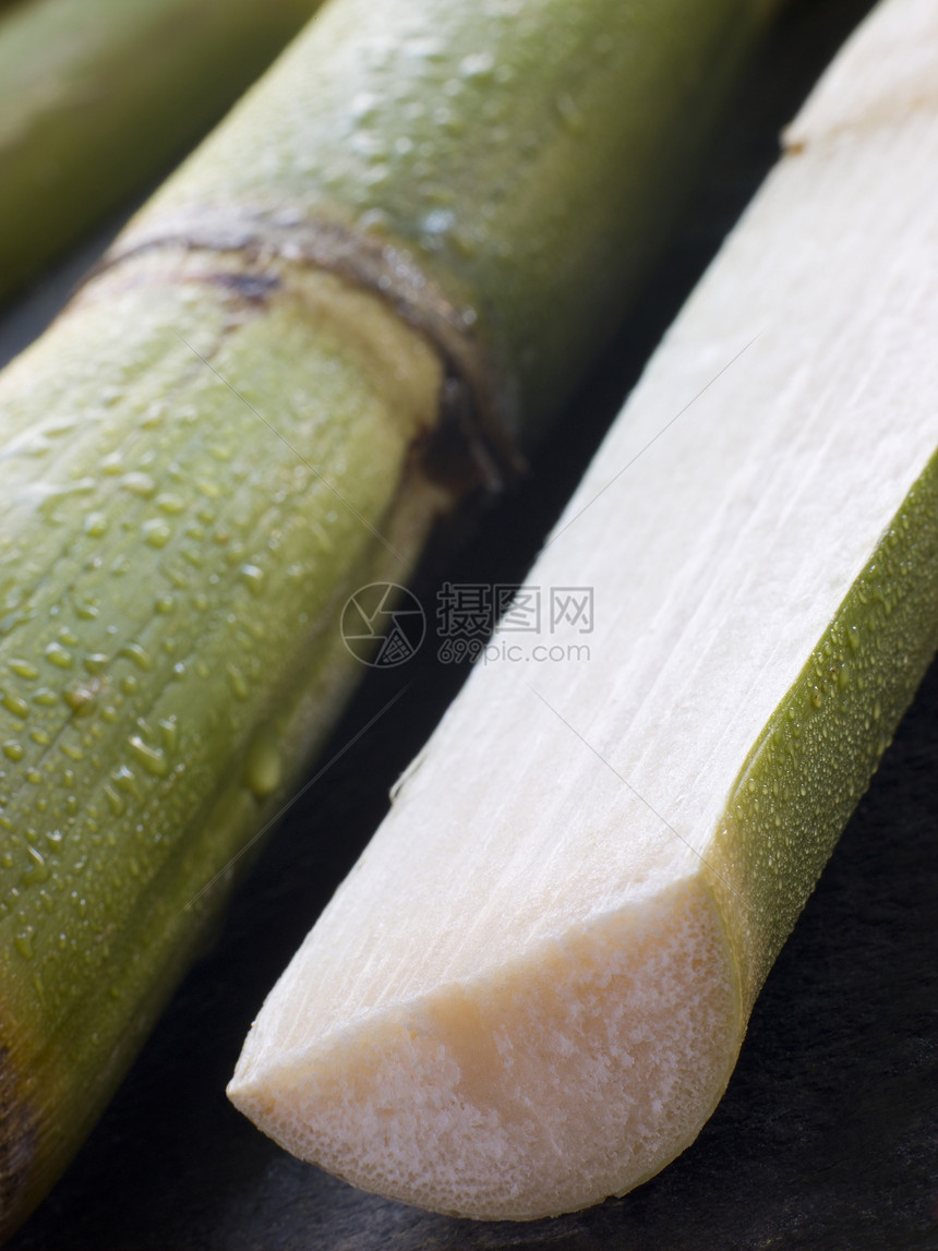 将新鲜甘蔗切成两半美食棕榈食品糖蜜食物图片