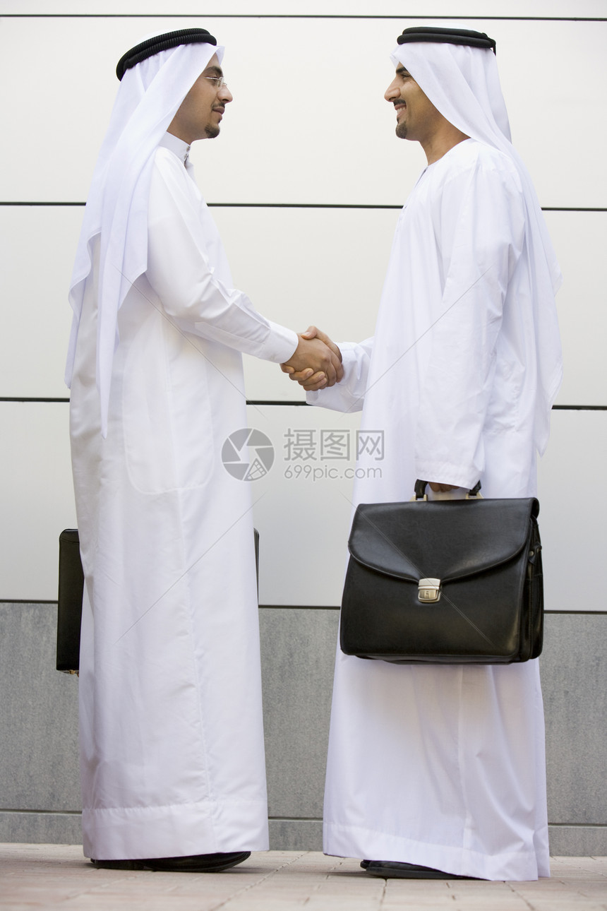 两个商务人士站在户外 拿着公文包微笑着外表会议衣服人士生意人同事人种情感商业商务图片