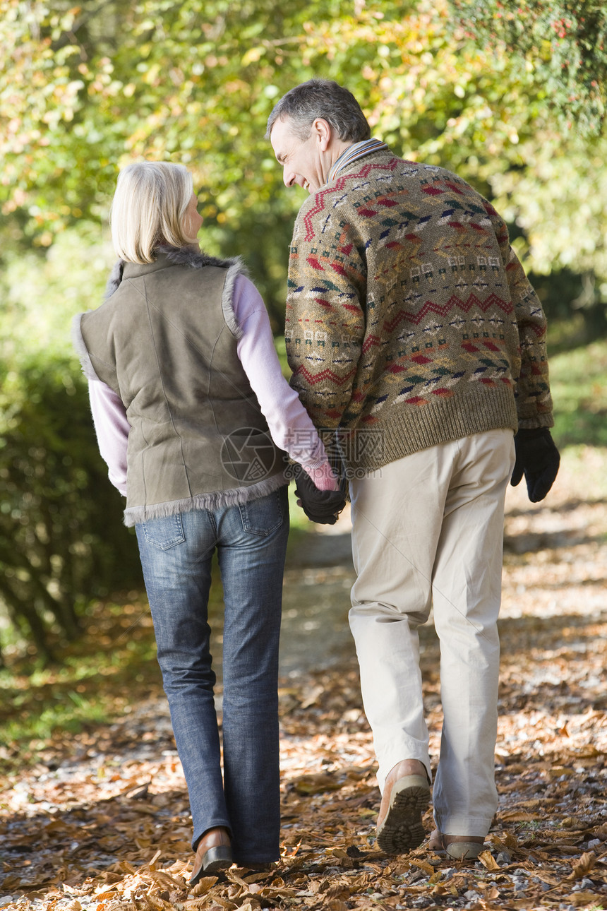 一对夫妇户外行走在公园的路上 手牵手微笑情感成年人树叶男性男人女性老化夫妻老年情绪图片