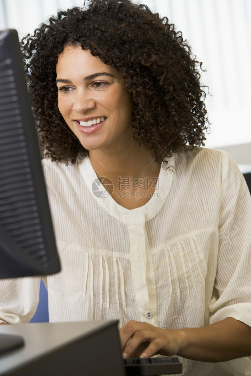 坐在计算机终端机打字高键上的妇女成人教育情绪电脑成年人服饰休闲服电脑室衣服中心校园图片