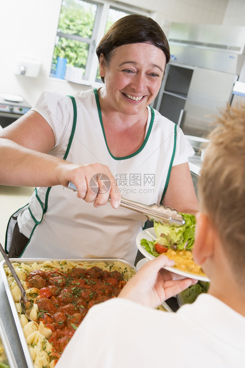 午餐女士向学生提供沙拉孩子成年人孩子们成人美食用餐亚裔同学们工人围裙图片