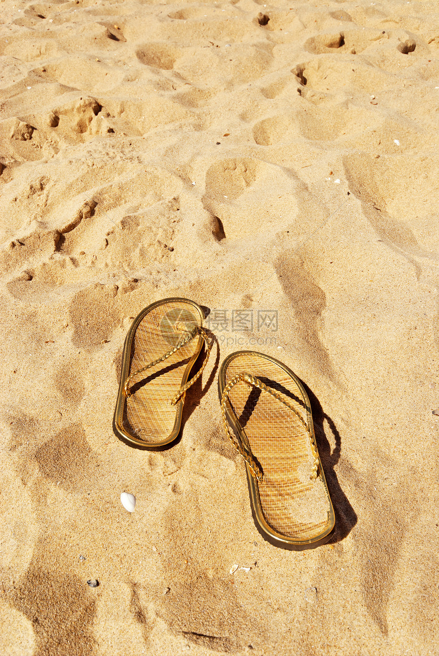 沙滩上的拖鞋压力假期旅行太阳衣服游泳凉鞋旅游支撑金子图片
