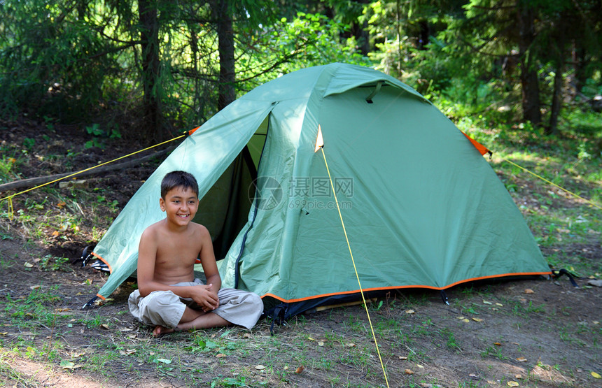 在帐篷附近微笑的男孩孩子露营者营地树木假期环境山脉森林灌木丛闲暇图片