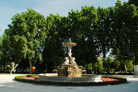 喷泉蓝色绿色公园树木白色天空雕塑背景图片
