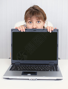 藏在笔记本电脑屏幕后面的年轻女孩高清图片