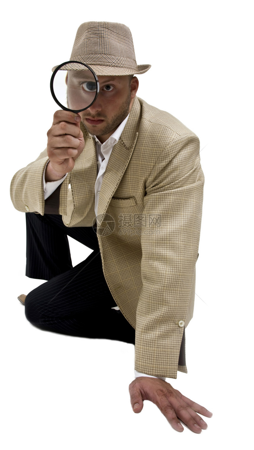 男人把放大镜放在眼睛的附近男性白色玻璃镜片套装工具衬衫帽子调查照片图片