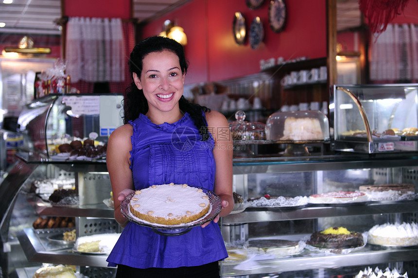 一家小商铺的老板 展示她美味的蛋糕面包师咖啡店职业柜台零售商女士业主衣冠微笑工作图片