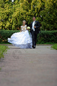 新婚夫妇夫妻绿色公园恋人男性女士婚礼男人投标花朵背景图片